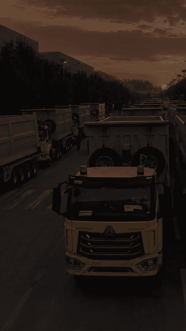 Rows of HOWO tractors with tipper trailers prepared for factory delivery