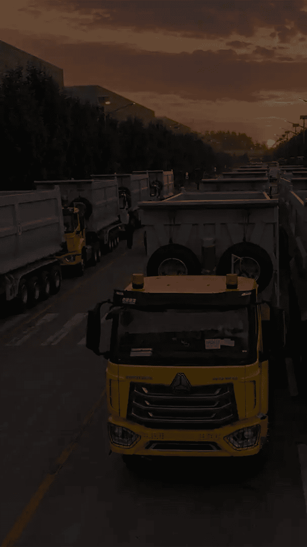 Rows of HOWO tractors with tipper trailers prepared for factory delivery