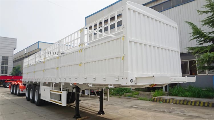 Front 45-degree view of Kales 60-ton fence semi-trailer featuring side tool box and safety guard rails.