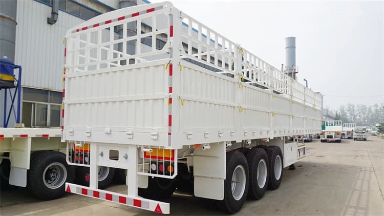 Rear 45-degree view of Kales 60-ton fence semi-trailer with dropsides and steel stakes, ideal for livestock and ventilated agricultural transport.
