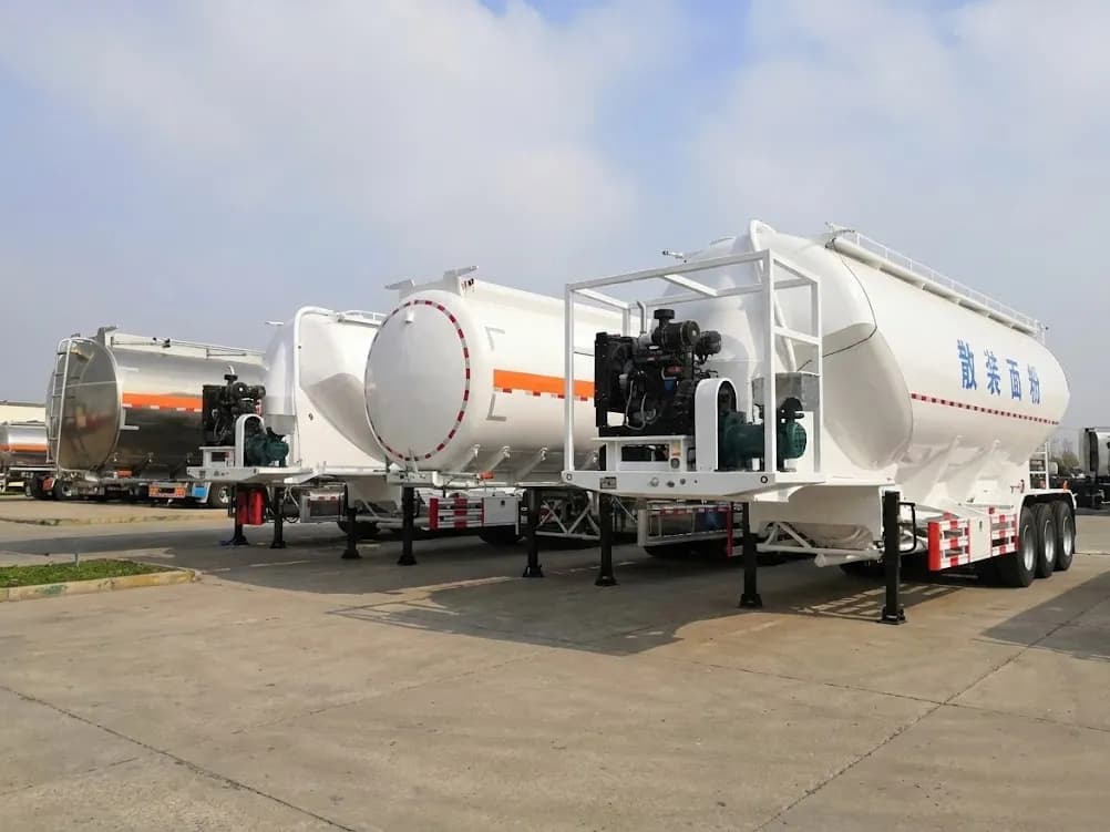 Lineup of Kales Vehicle liquid and powder transport trailers featuring aluminum fuel tankers and pneumatic bulk flour tankers with diesel engines.