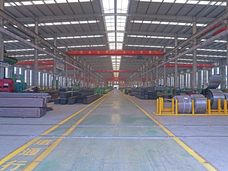 Organized raw material storage area at Kales Vehicle factory featuring high-strength steel plates.